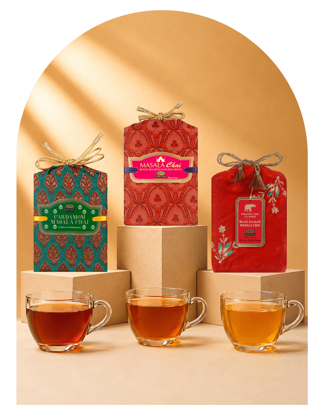 Three packaged tea products displayed on pedestals with glass cups of brewed tea and spices arranged in front, set against a warm beige background with a soft arch shadow.