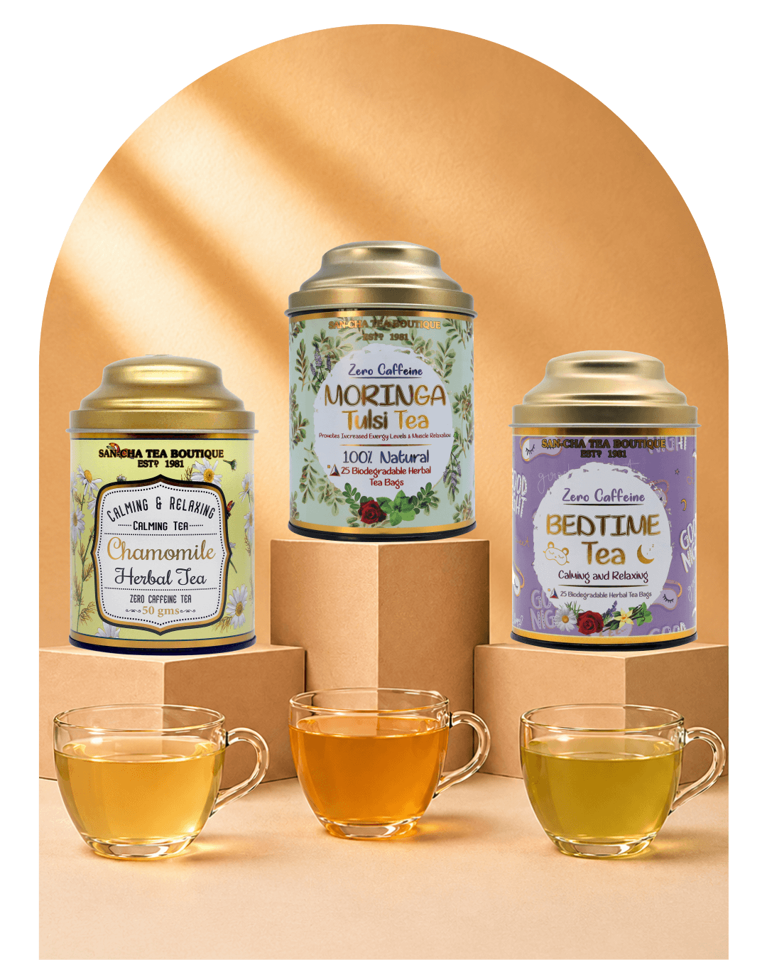 Three tea tins in different colors (yellow-green, green, and purple) with gold lids are displayed on cardboard risers with three glass teacups in front on a beige background with a soft arch shadow.